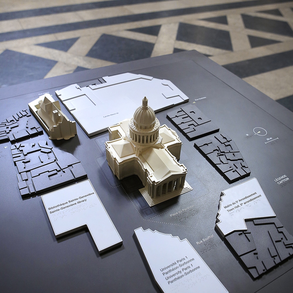 A 1/200 scale 3D architectural model of the building set in its urban surroundings