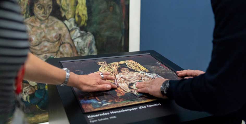 Visiteurs touchant la station tactile de l'interprétation au Musée du Belvédère à Vienne