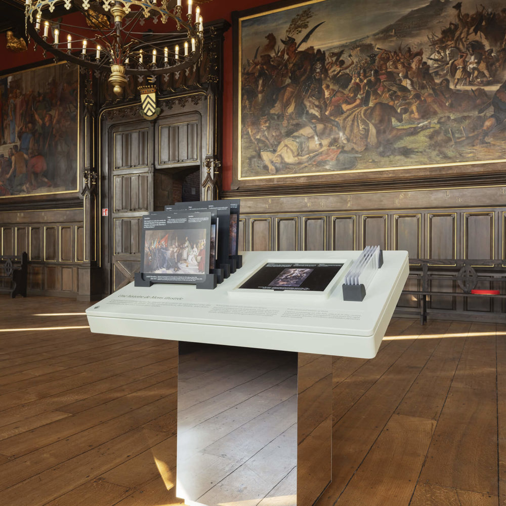 Manipe d'observation de cinq tableaux, dans la salle gothique de l'hôtel de ville de Mons. Crédits Louis Matton.